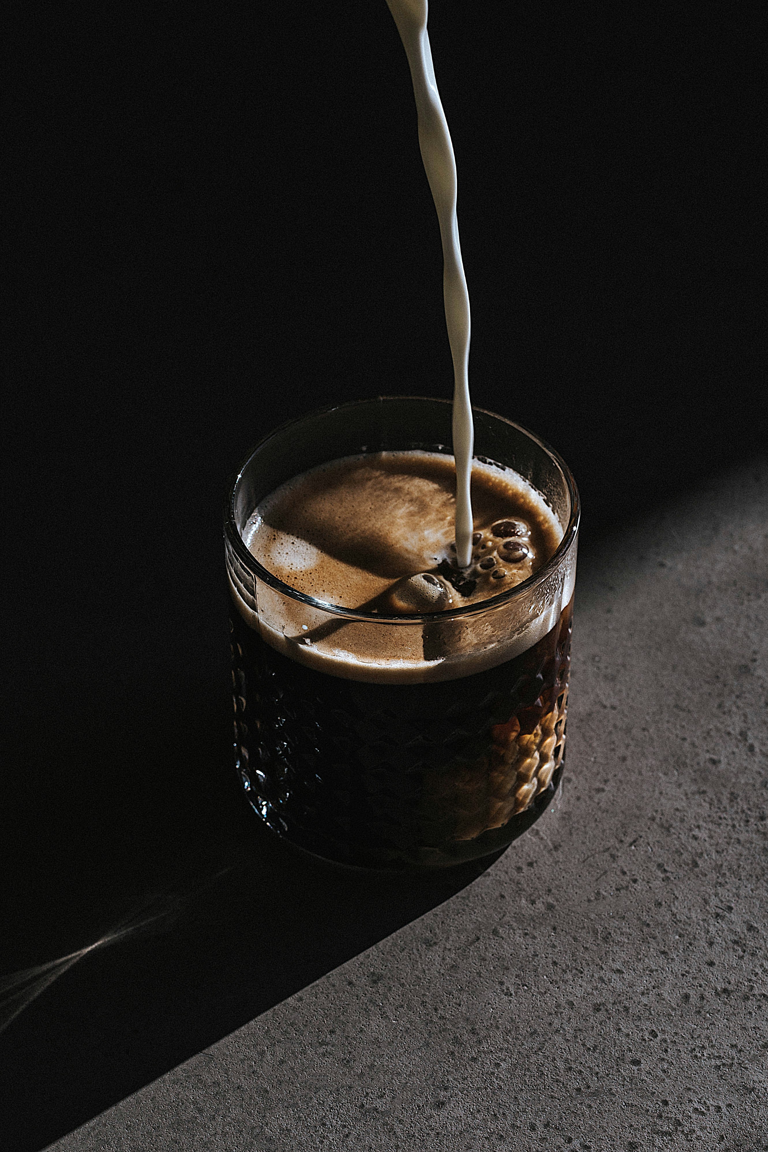 Coffee being poured in dramatic lighting