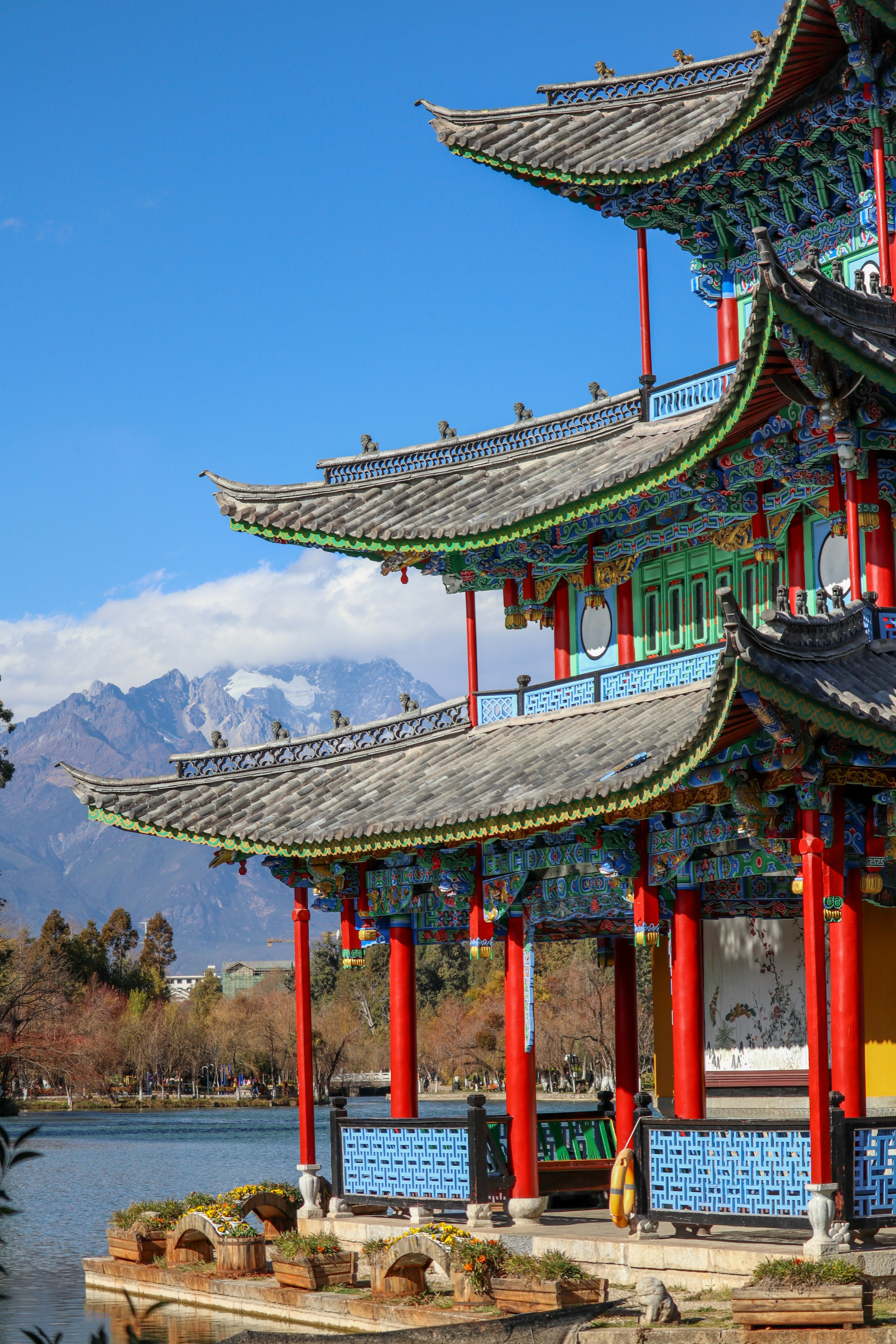 Traditional Yunnan architecture with snow-capped mountains